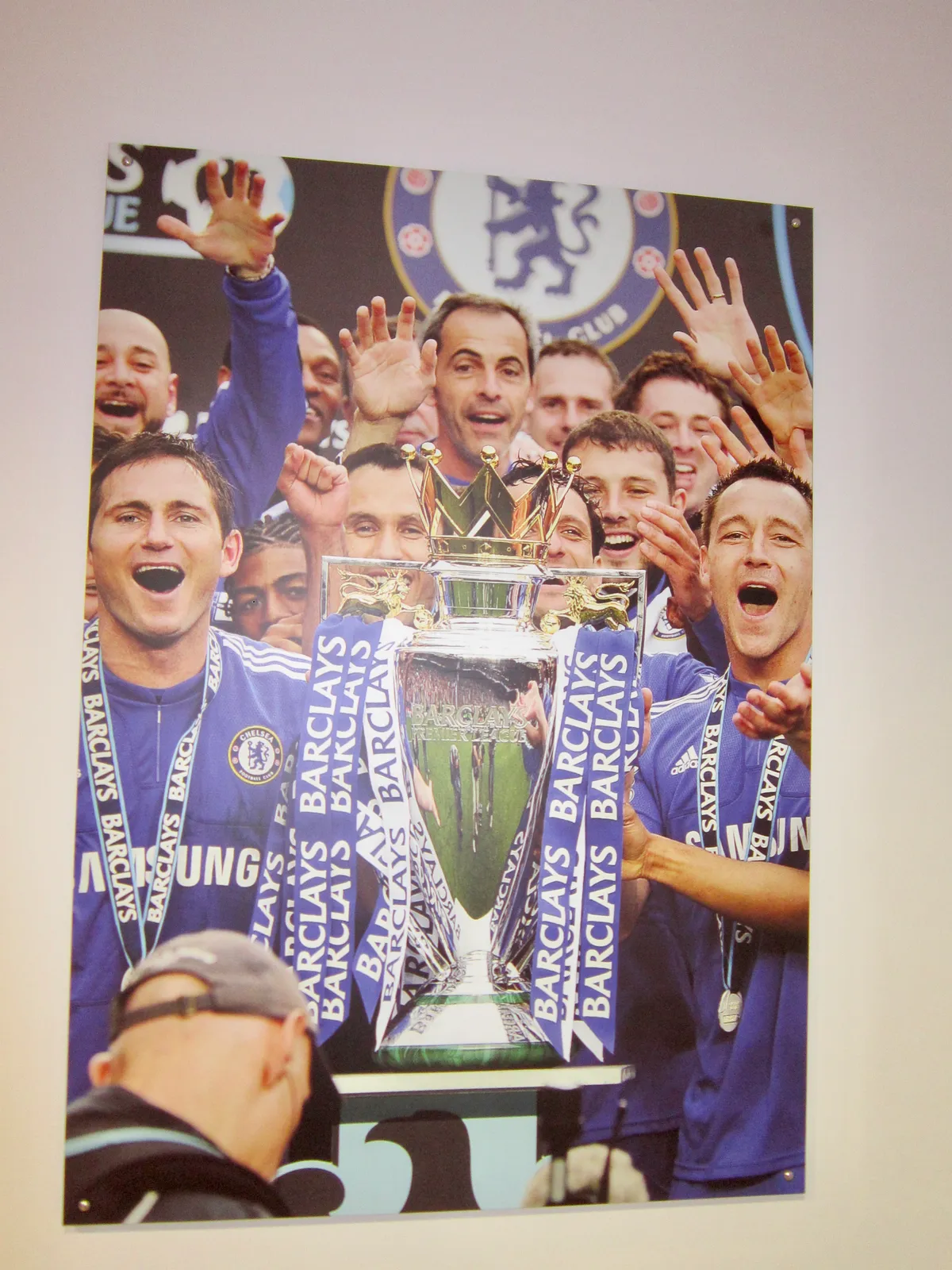Wall display of Chelsea players lifting a trophy in the Chelsea FC Museum at Stamford Bridge