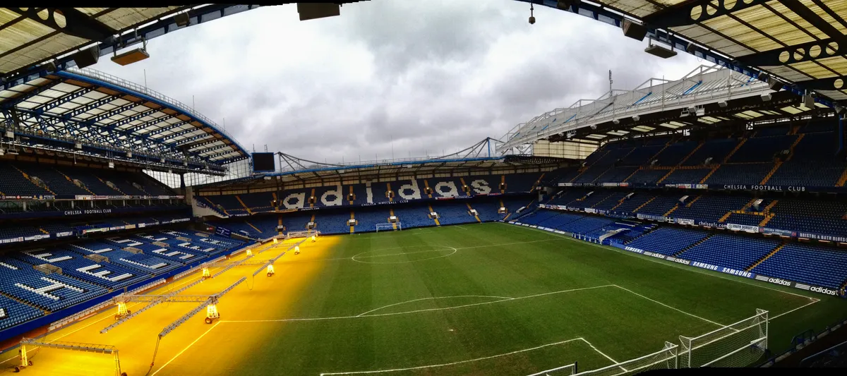 Wide view across the pitch and stands at Stamford Bridge from pitchside on a Chelsea stadium tour in London